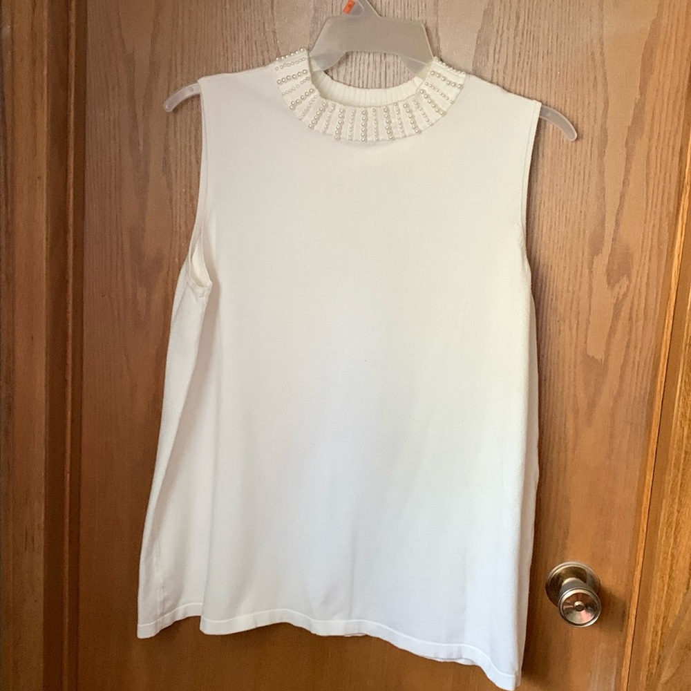Sleeveless knit turtleneck type sweater with pearls around the neck